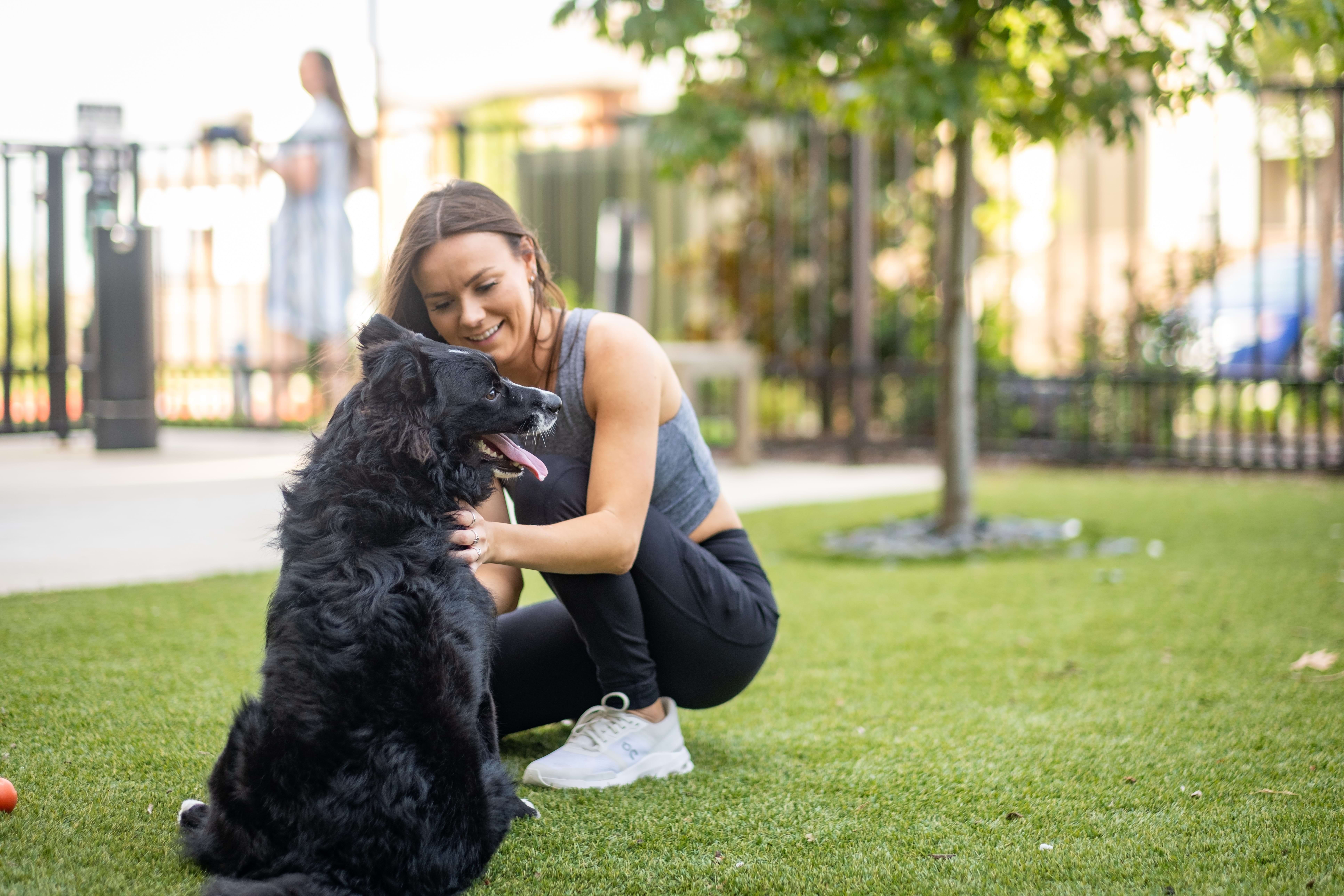 A Resident Playing with Their Dog Outside at Our Cortland Apartment Community