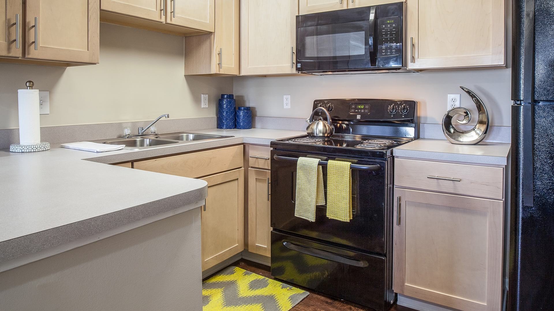 Kitchen with Black Appliances at Our Brice Rd Apartments