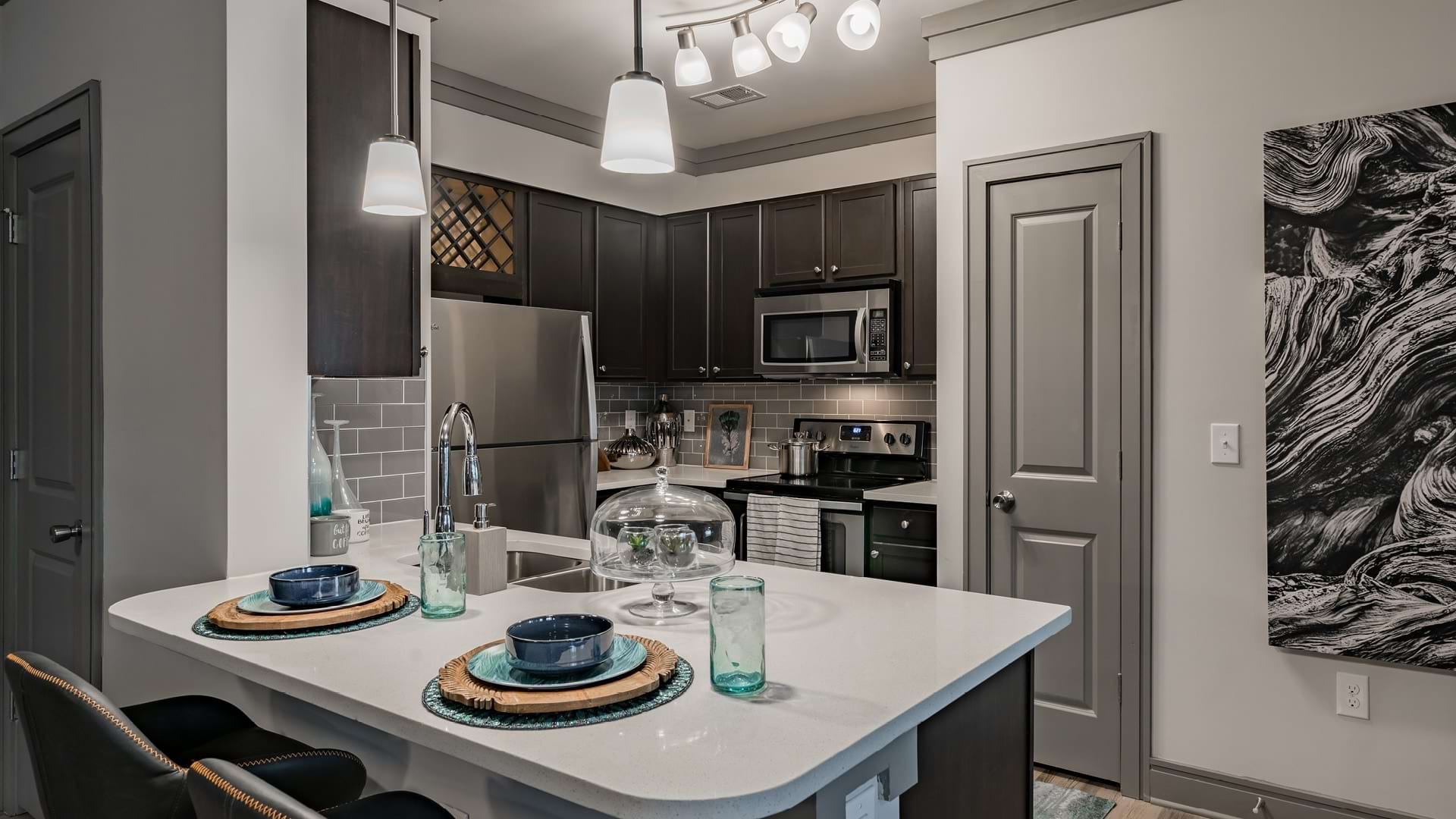 Kitchen with modern lighting and quartz countertops at our upscale apartments in Raleigh, NC