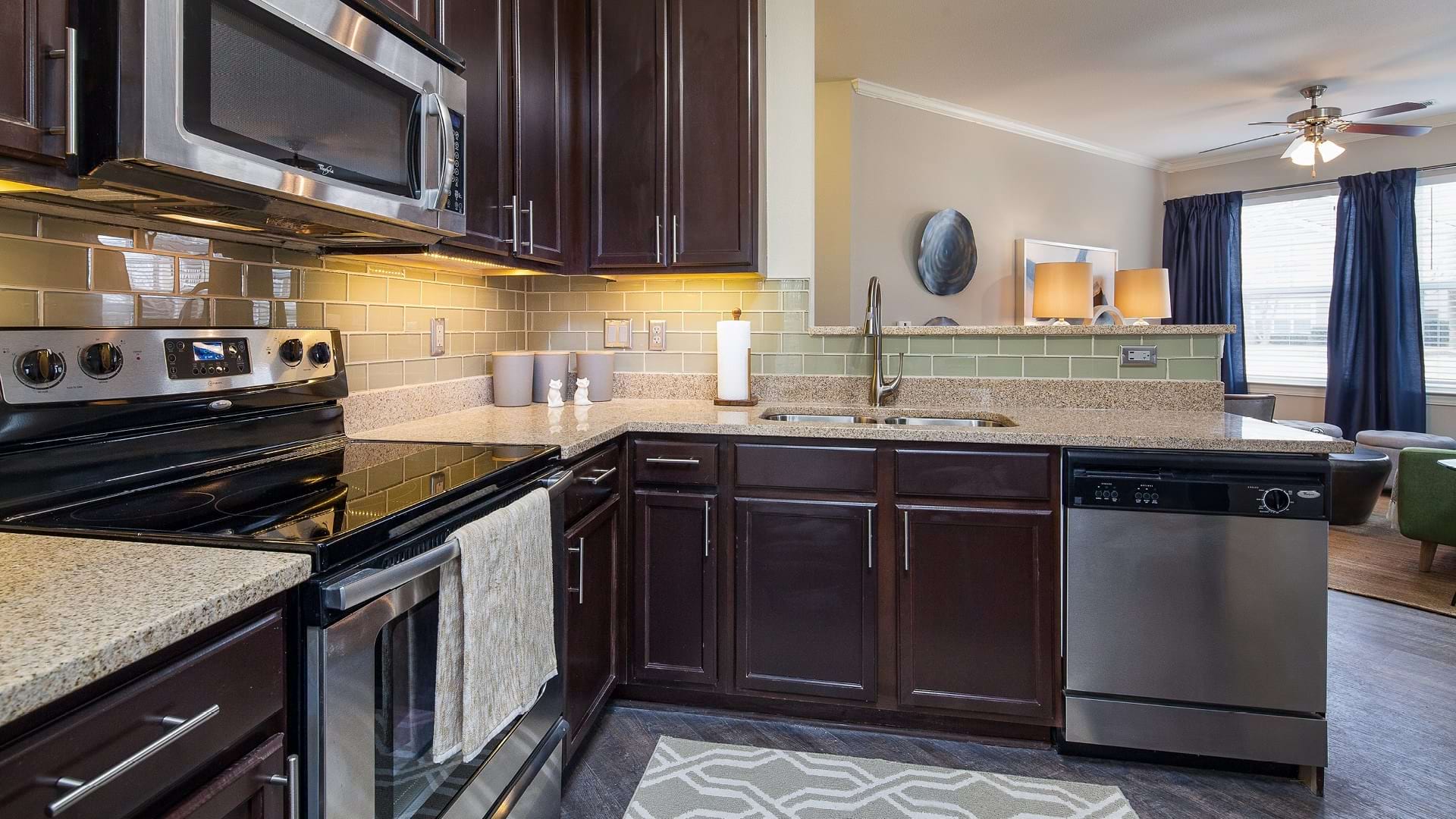 Modern Kitchen with Sleek Granite Countertops and Stainless Steel Appliances at Our University Area Apartments
