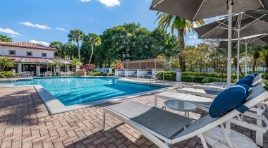 Poolside Lounge Chairs and Umbrellas at Our Apartments for Rent in Hammocks
