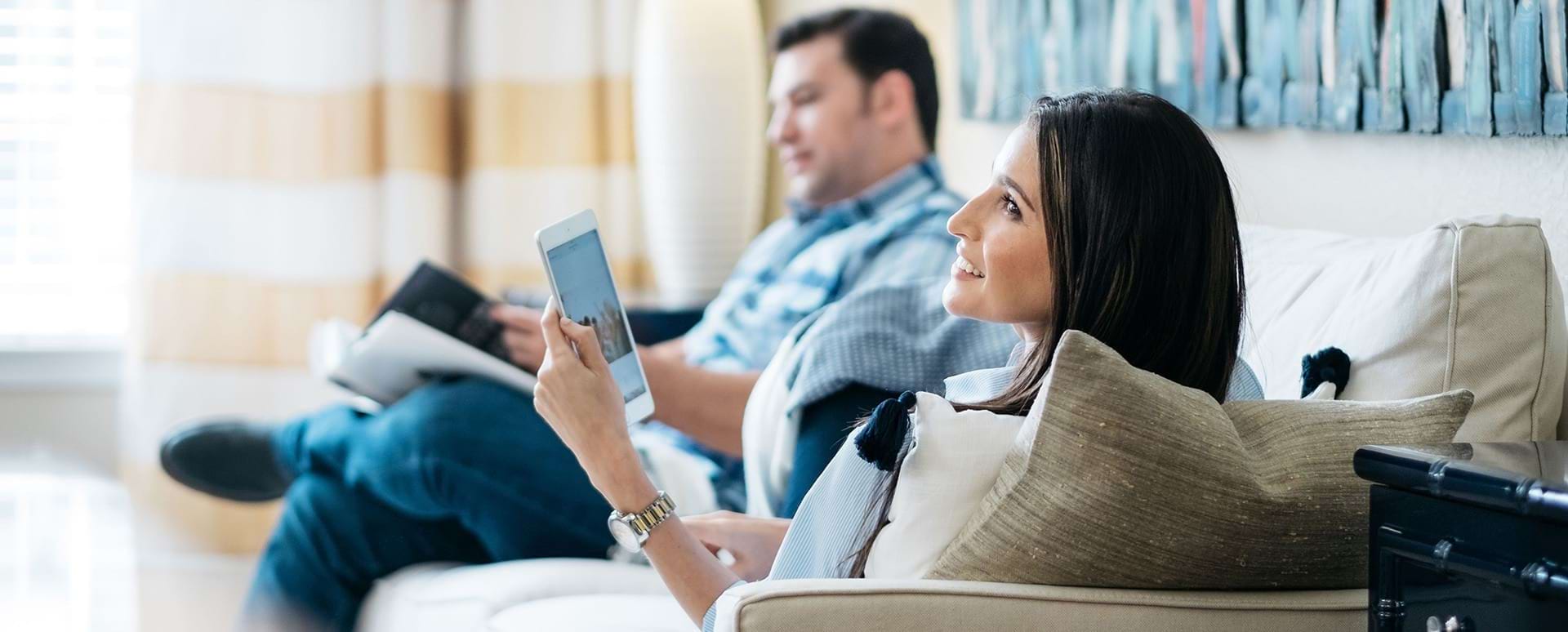 Residents Reading on Their Couch at Our Cortland Apartments