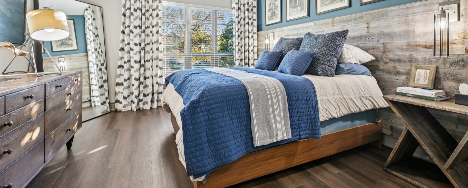 Bedroom with Wood-Style Flooring and Accent Wall at Our Modern Apartments Near Raleigh, NC