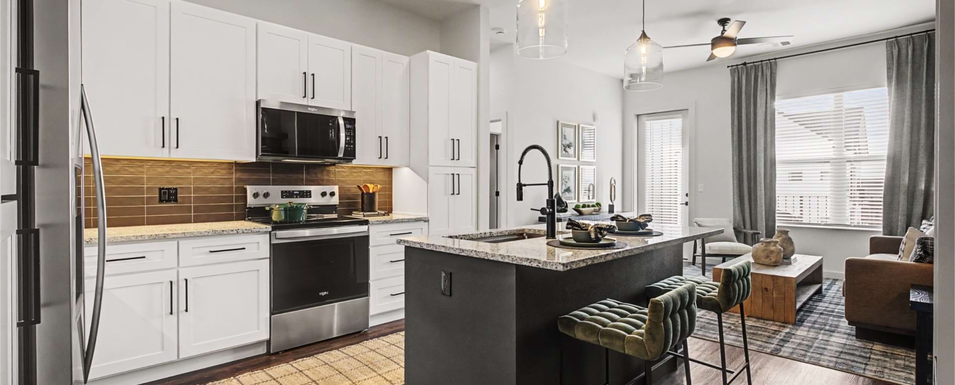 Modern Cabinetry with Designer Hardware and Tile Backsplash at Our Apartments Near Peterson AFB