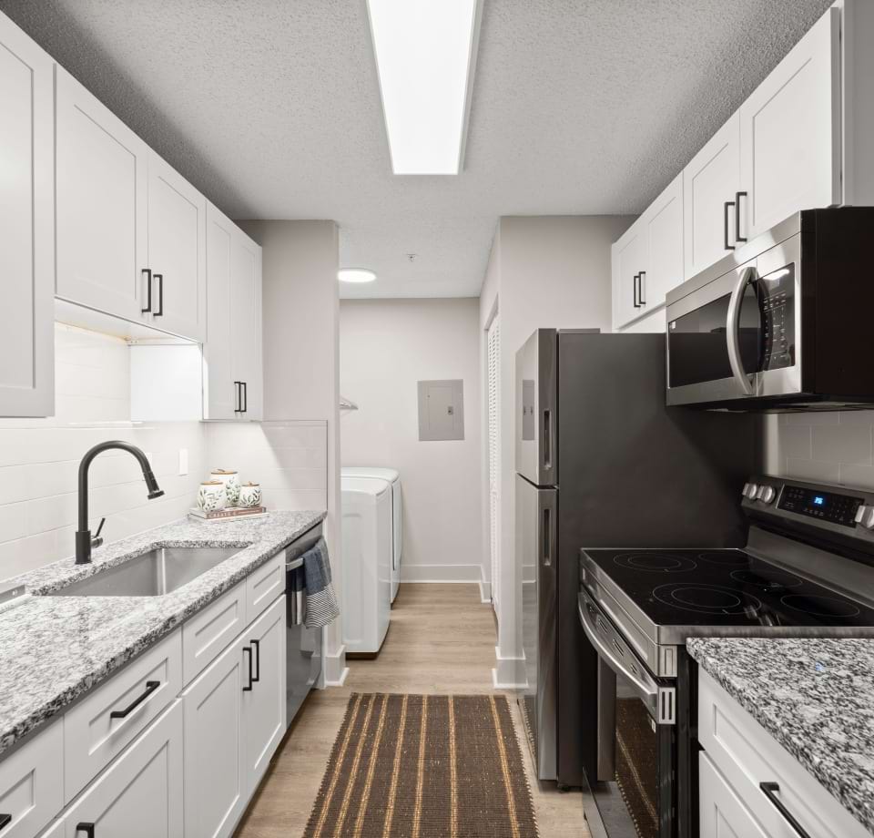 Kitchen with Wood-Style Flooring at Our Eagles Landing Apartments in GA