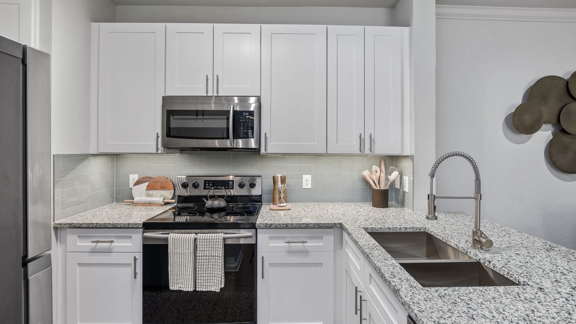 Modern apartment kitchen with granite countertops and stainless steel appliances at our apartments in West Plano, TX