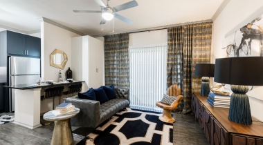 Spacious living room with nine-foot ceilings, crown molding, and ceiling fans at our Dallas North Apartment community