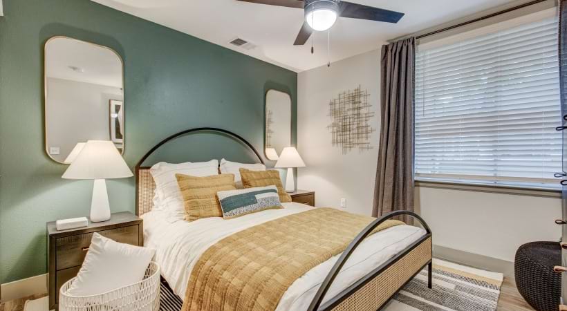 Spacious Bedroom with Large Window and Ceiling Fan at Our Northglenn Apartments