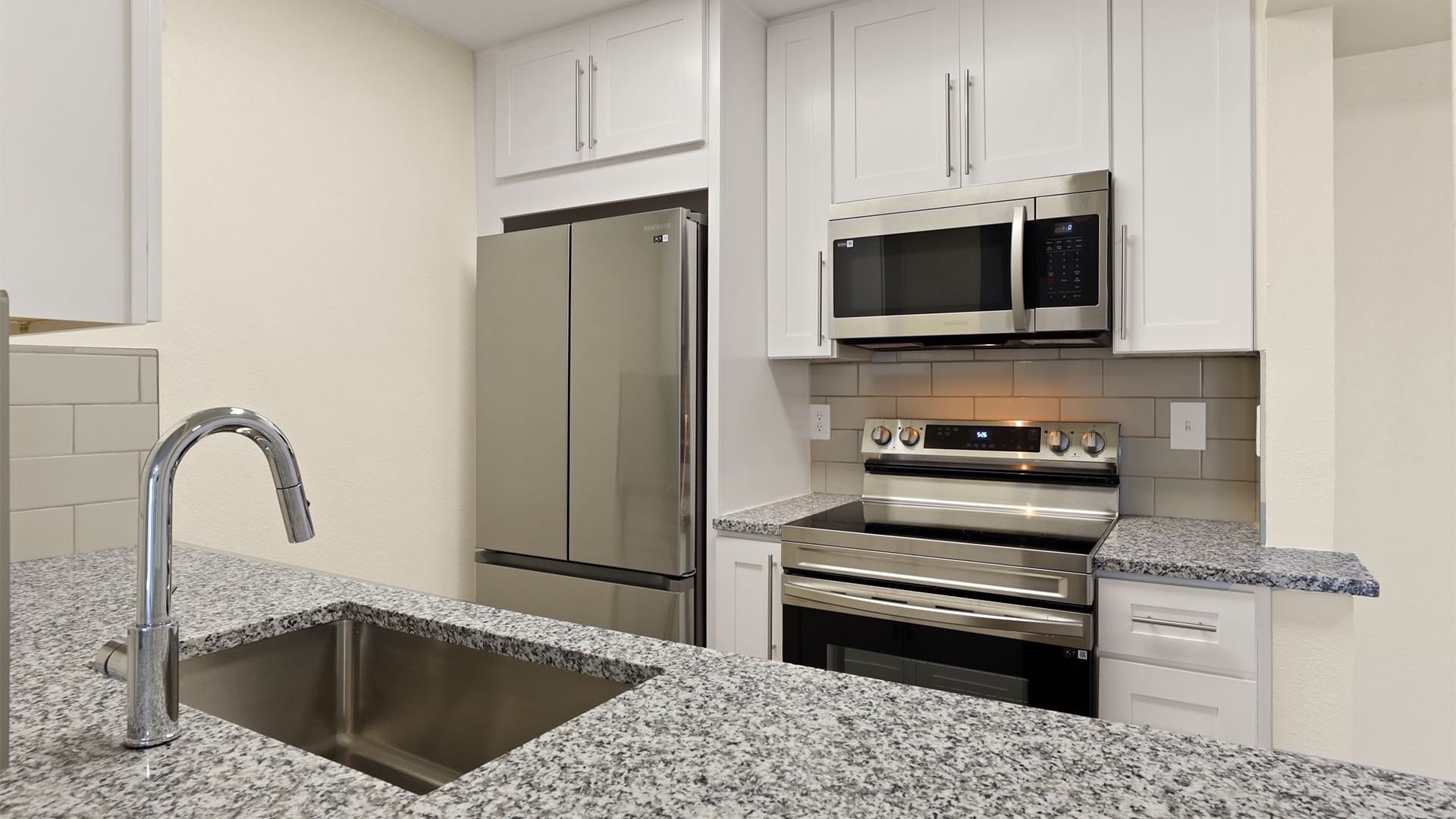 Kitchen with White Cabinetry and Energy-Efficient Stainless Steel Appliances at Our Catalina Foothills, AZ Apartments