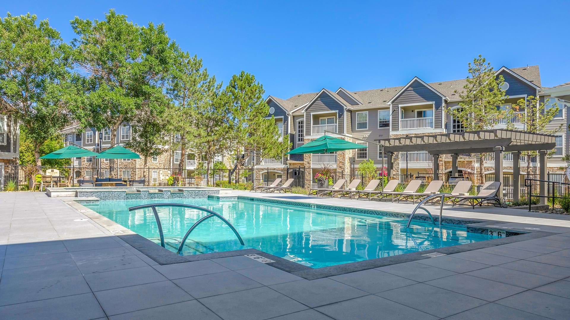 Sparkling, Resort-Style Pool Surrounded by Lounge Chairs at Our Apartments Near Northglenn, Colorado