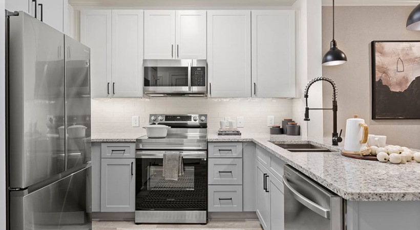 Upscale Kitchen With Quartz Breakfast Bar And Stainless Steel Appliances 