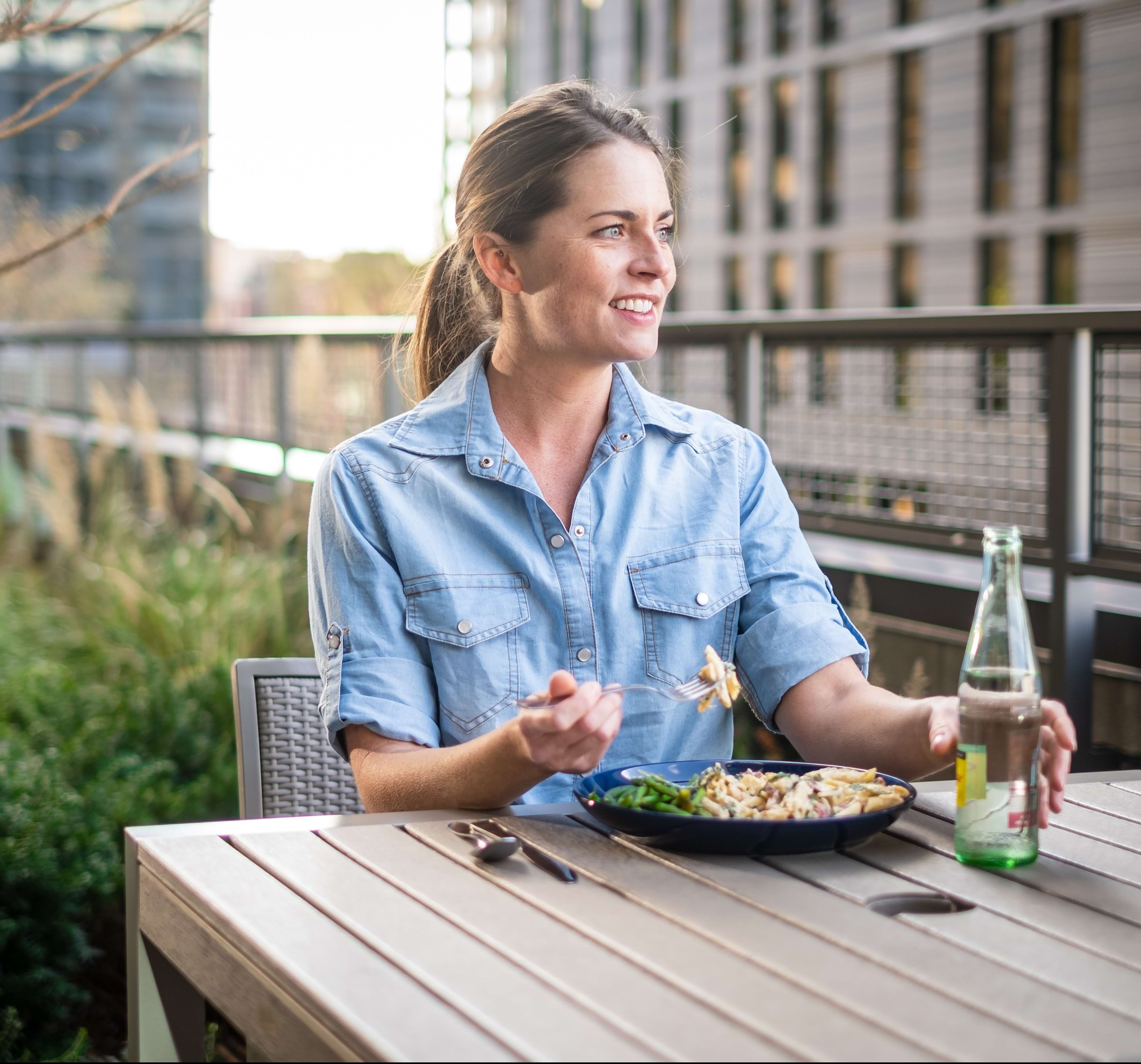 Woman Enjoying a Meal Outdoors at Our Cortland Apartments