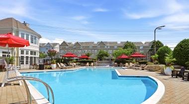 Resort-Style Pool and Sun Deck with Lounge Chairs Nearby at Our Dulles Town Center Apartments