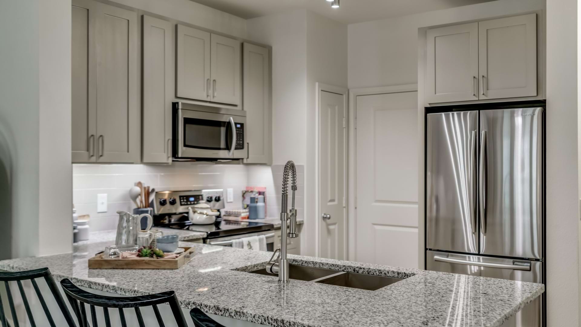 White-theme kitchen with stainless steel appliances at our luxury apartments near Las Colinas