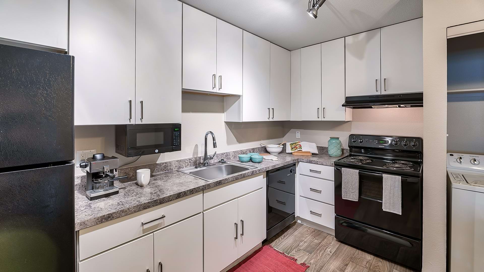 Kitchen with Granite-Style Countertops and White Cabinetry at Our Gilbert Apartments for Rent