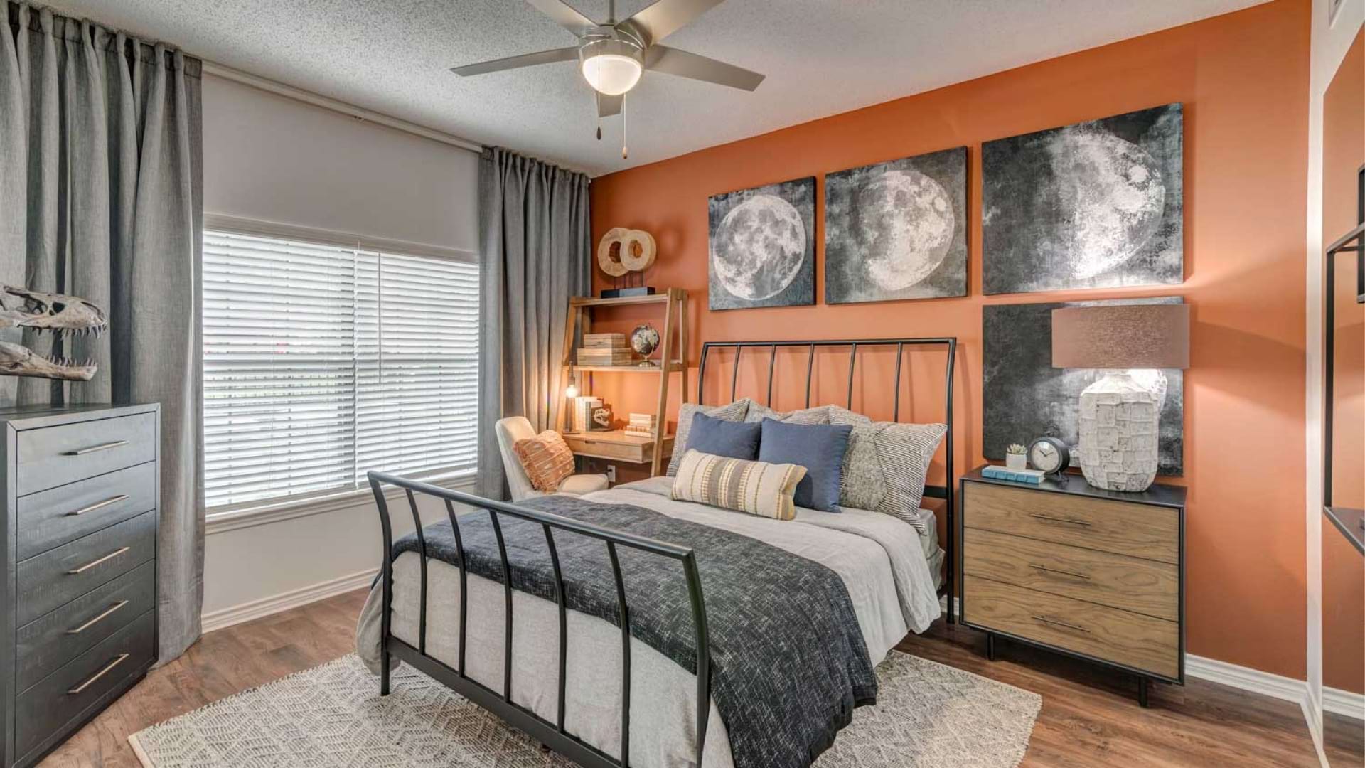 Modern apartment bedroom with wide windows and wood-style flooring at our apartments for rent in Irving, TX