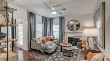 Modern apartment living room with natural lighting and wood-style flooring at our luxury apartments in Irving, TX