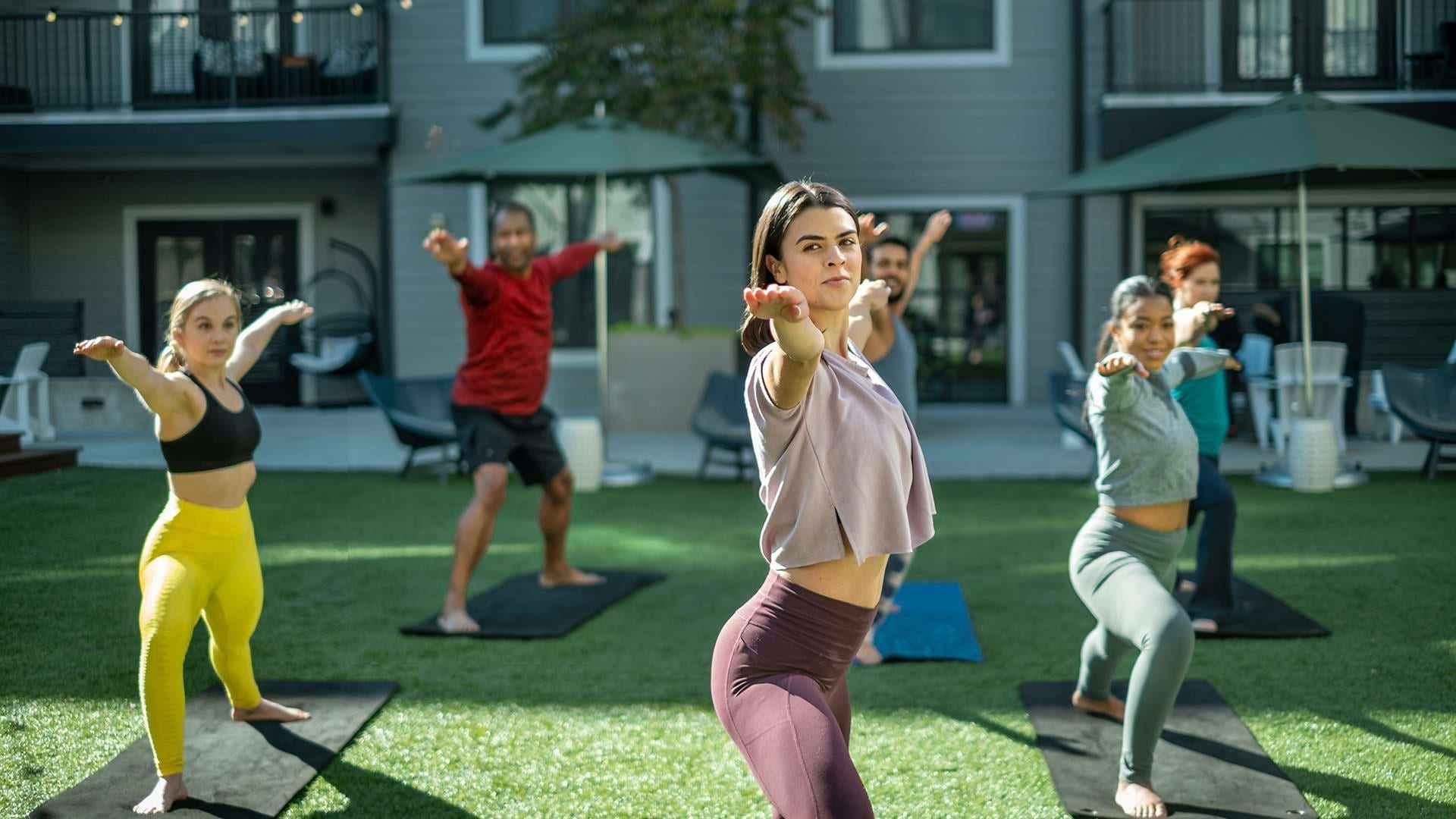 A Group of Cortland Apartment Residents Participating in an Outdoor Yoga Class