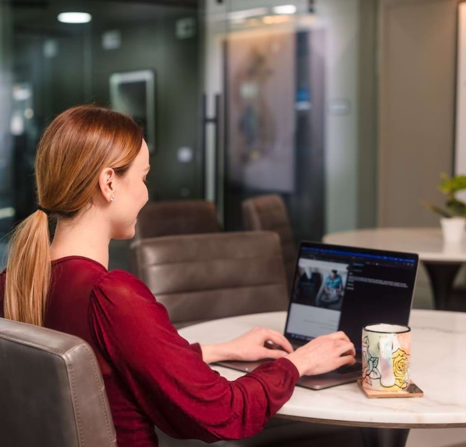 Cortland Apartment Resident Working on Her Laptop in Our Resident Clubhouse